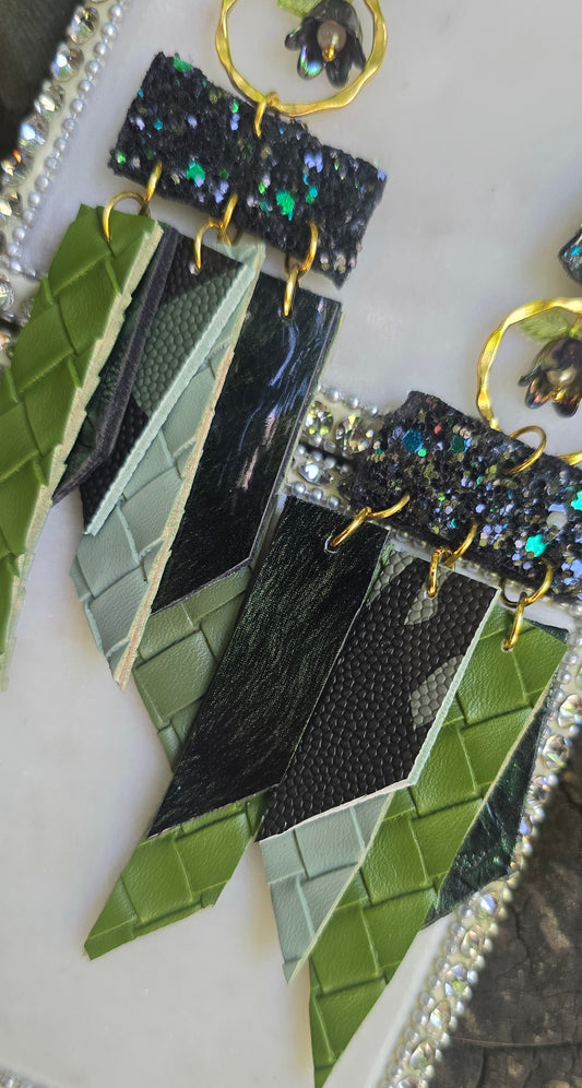 Green glittery fringe earrings called Ruth from Shop Moxxc hanging with shimmering details and fringe design on a white background.