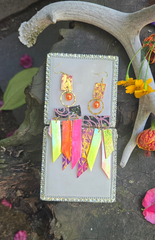 Bright yellow fringe earrings from Shop Moxxc featuring long tassels and gold hooks, displayed against a neutral background.