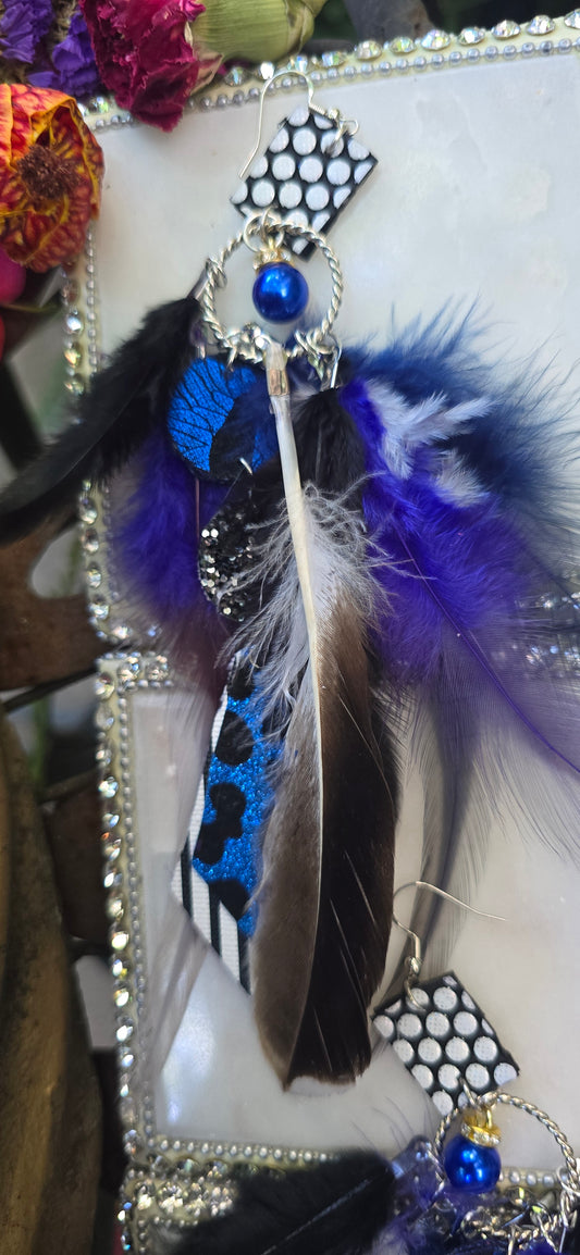 Blue animal print feather earrings featuring long feathers, styled with intricate details, from Shop Moxxc.