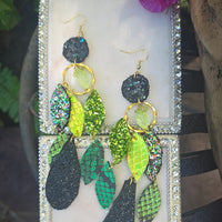Green geometric dangle earrings from the Shannon collection by Shop Moxxc featuring modern design and intricate shapes.