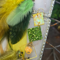 Green boho festival feather earrings by Claire, showcasing vibrant feathers and intricate design perfect for stylish outfits.