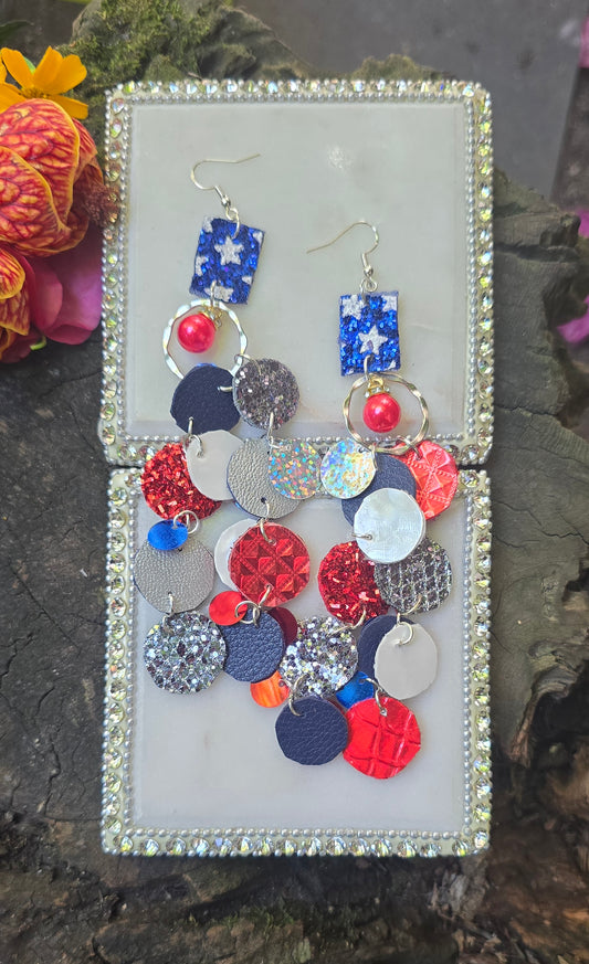Red and blue sparkly round dangle earrings from Shop Moxxc, featuring a shiny, festive design with sparkling embellishments.