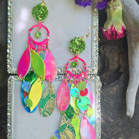 Bright multicolored layered earrings from Shop Moxxc featuring vibrant, dangling jewelry with various colorful geometric shapes.