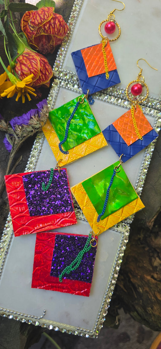 Jelena Rainbow Statement Earrings by Shop Moxxc featuring colorful, bold hoop earrings with rainbow design and gold accents.