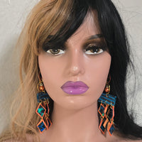 Orange geometric fringe earrings featuring bold, modern design from Shop Moxxc, with intricate fringe detailing.