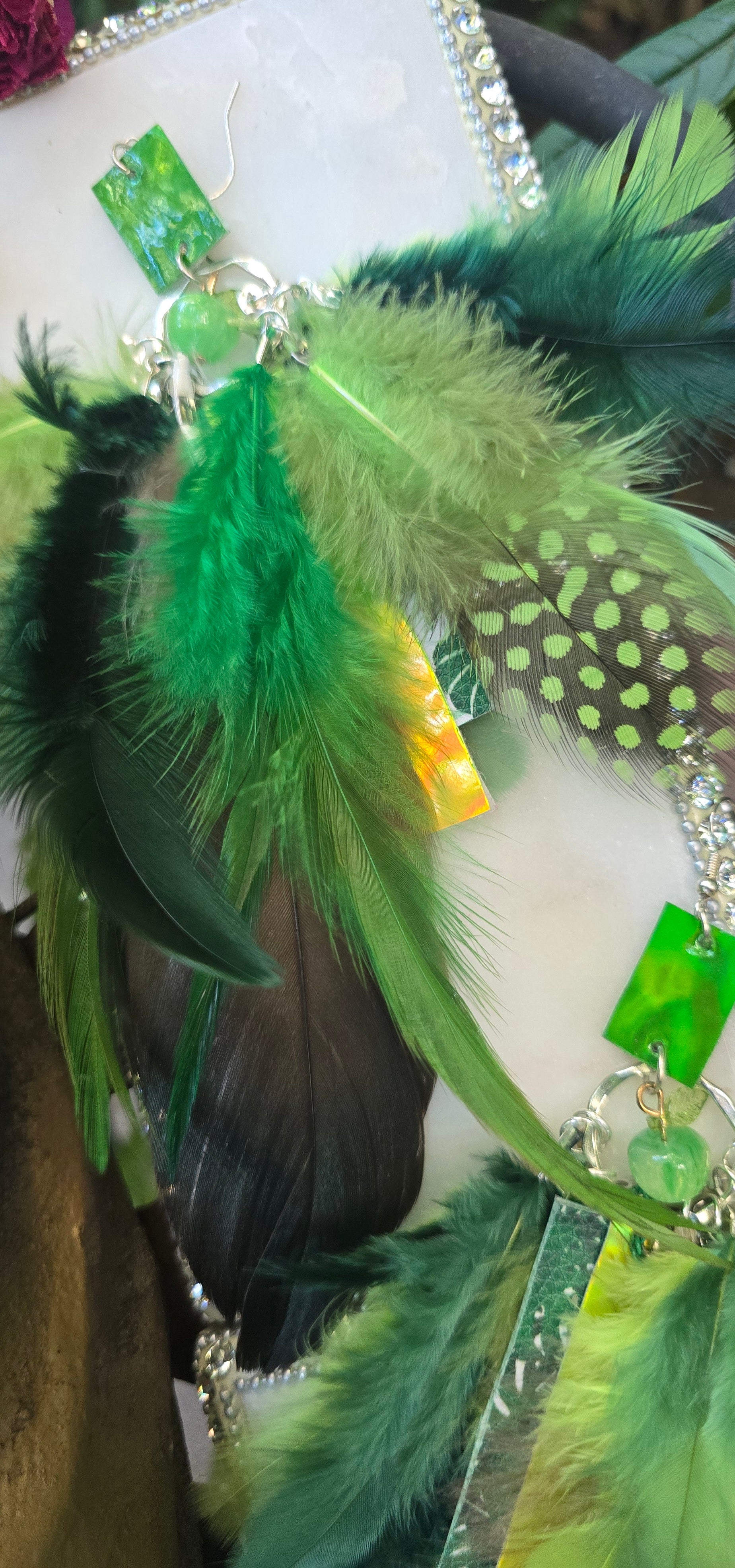 Green feather boho earrings by Shop Moxxc featuring layered feather design and intricate bead accents.