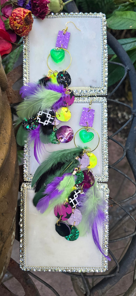 Purple and green round feather earrings featuring layered feathers, designed by Shop Moxxc, hanging from gold hooks.
