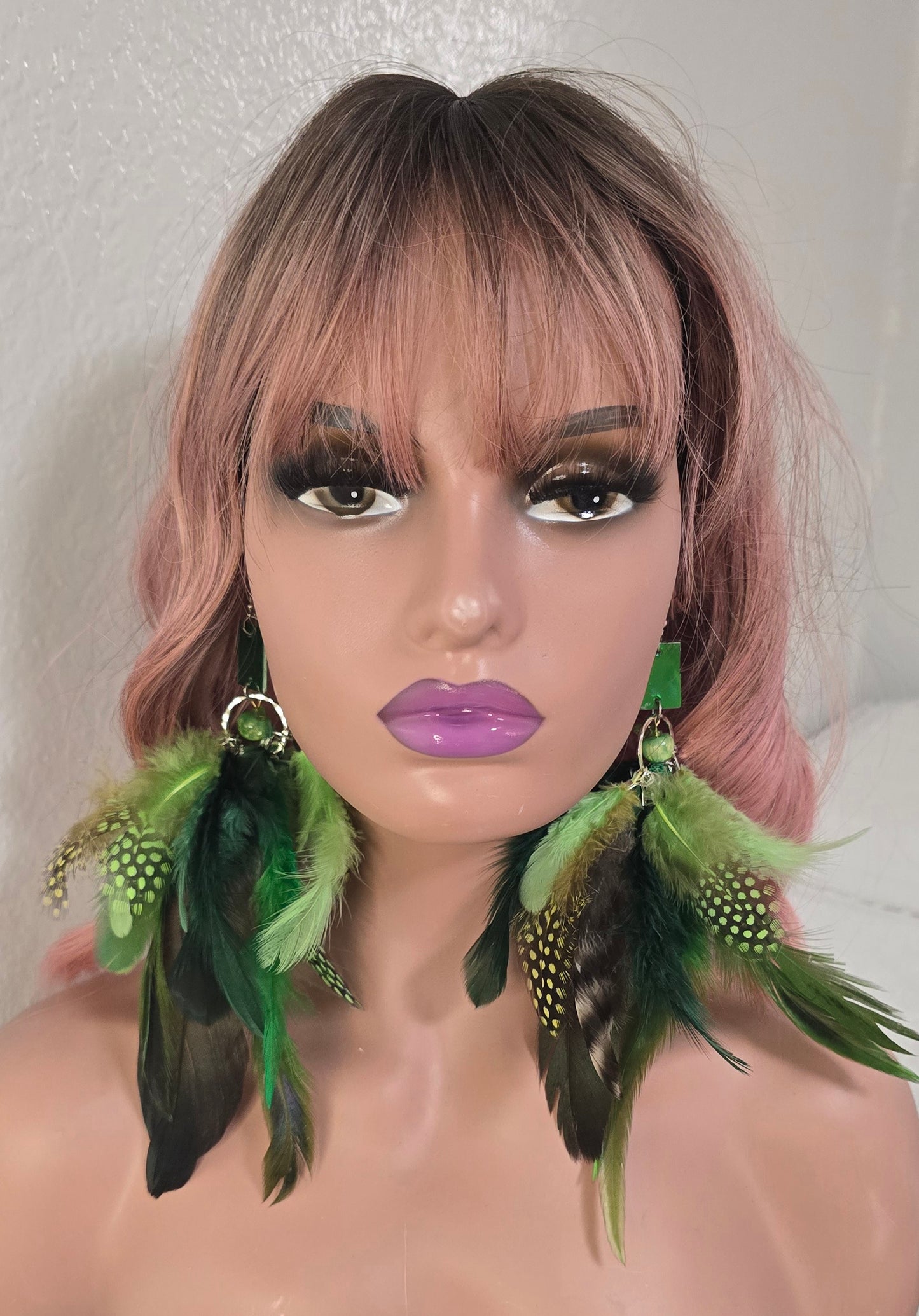 Green feather boho earrings featuring layered feathers and intricate bead details, perfect for bohemian-style accessories.